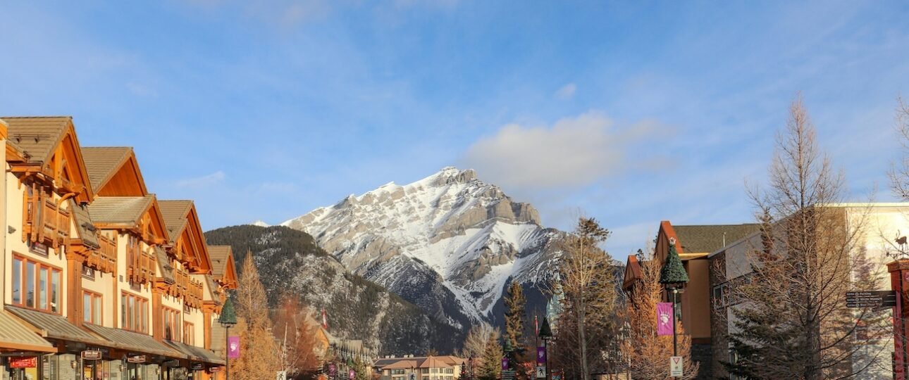 Lively interior of the Rose & Crown pub on Banff Avenue at night with live music on stage, people at the bar, and warm amber lighting, Banff, Alberta, Canada