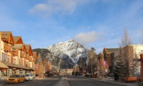 Lively interior of the Rose & Crown pub on Banff Avenue at night with live music on stage, people at the bar, and warm amber lighting, Banff, Alberta, Canada