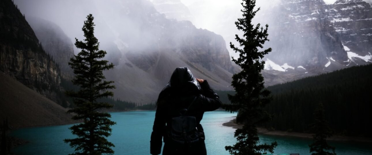 Side-by-side view of Banff National Park in winter with snow-covered peaks and summer with turquoise Moraine Lake under blue skies