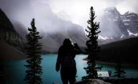 Side-by-side view of Banff National Park in winter with snow-covered peaks and summer with turquoise Moraine Lake under blue skies