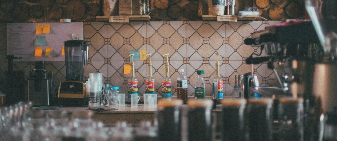 A perfectly poured latte with latte art in a ceramic cup at Eclipse Coffee Roasters, with the Canadian Rocky Mountains visible through the café window, Canmore, Alberta