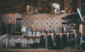 A perfectly poured latte with latte art in a ceramic cup at Eclipse Coffee Roasters, with the Canadian Rocky Mountains visible through the café window, Canmore, Alberta