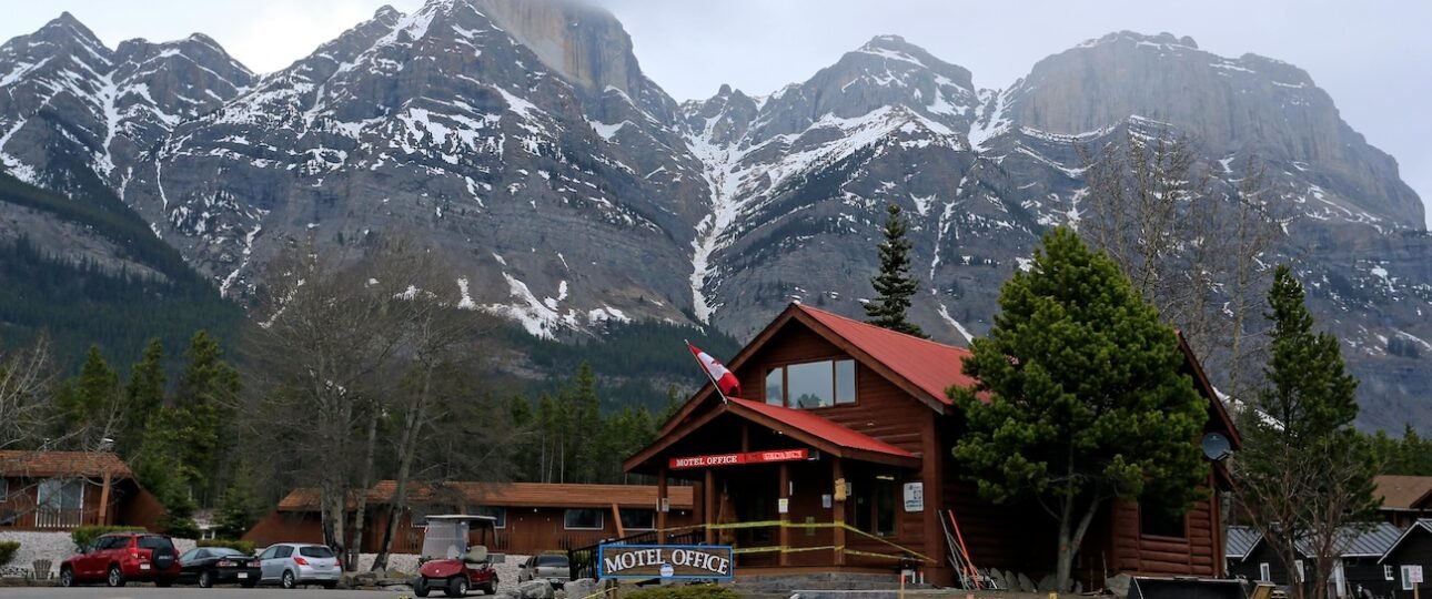 Aerial view of the Fairmont Banff Springs hotel surrounded by autumn forest and snow-capped Rocky Mountain peaks in Banff National Park, Alberta
