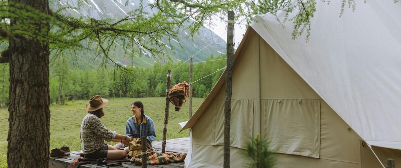 Lit geodesic dome tent glowing warmly against a star-filled night sky in the Canadian Rockies near Jasper National Park, Alberta, Canada