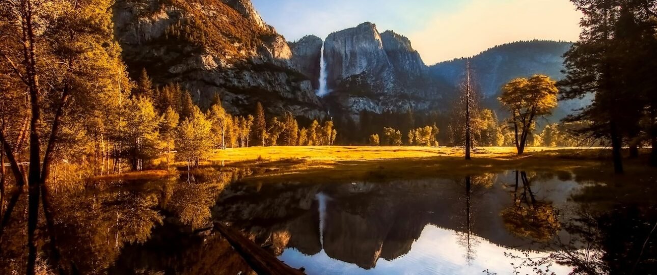 Parks Canada Discovery Pass displayed on a car dashboard at the Banff National Park entrance gate, with mountain peaks visible through the windshield, Alberta, Canada