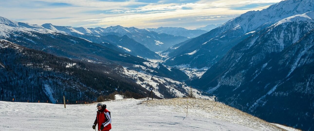 Split view of skiers on the open alpine terrain at Sunshine Village and the forested runs at Lake Louise ski resort, Banff National Park, Alberta, Canada