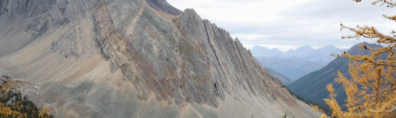 Turquoise waters of Upper Kananaskis Lake in Peter Lougheed Provincial Park with forested mountain slopes reflected on the surface