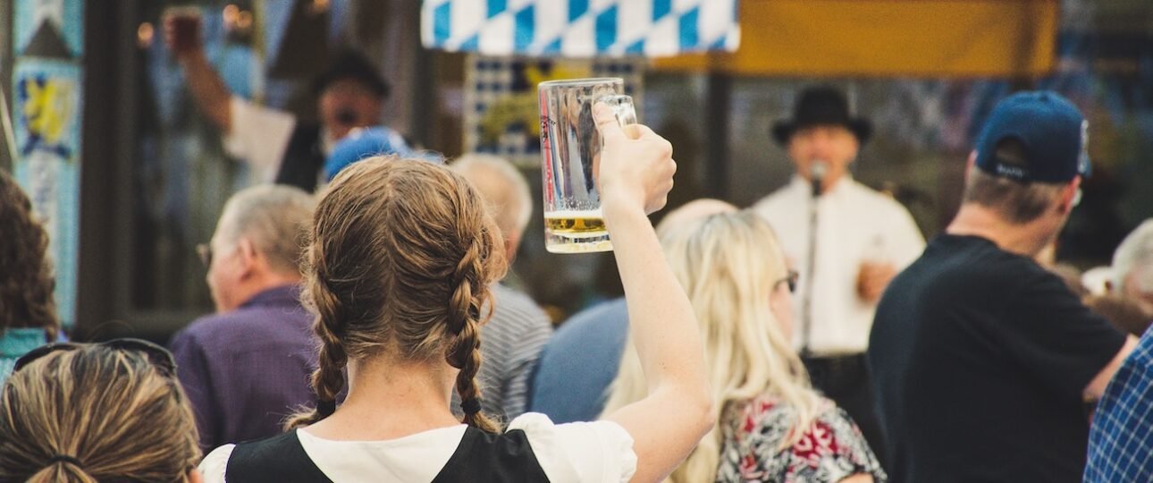 People celebrating at Oktoberfest Edmonton 2026 at ICE District Fan Park with beer steins and live music