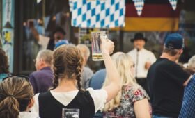 People celebrating at Oktoberfest Edmonton 2026 at ICE District Fan Park with beer steins and live music